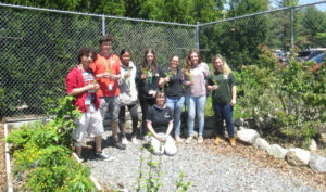 Greater New Bedford Vocational Technical School students stand in front of their rain and butterfly garden. 